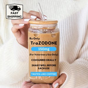 May include: A clear glass jar with a wooden lid and a clear straw, filled with a light brown liquid. The jar has text that reads "Rx Only TraZODONE 150mg (For Veterinary Use Only) CONSUMED ORALLY SHAKE WELL BEFORE EACH USE TASTES LIKE COFFEE!"