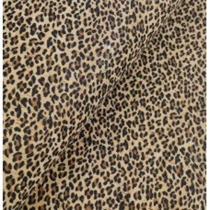 May include: Brown and black leopard print fabric with a subtle yellow undertone.