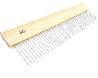 Könnte beinhalten: Ein Holzkamm mit einem langen, dünnen Griff und einer Reihe von Metallzähnen. Der Kamm ist mit "karin" beschriftet.