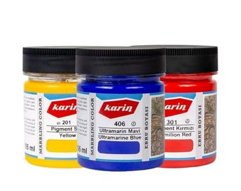 May include: Three 105 ml jars of marbling paint in yellow, blue, and red. The jars are labeled with the brand name "karin" and the color names "Pigment Yellow", "Ultramarine Blue", and "milion Red".