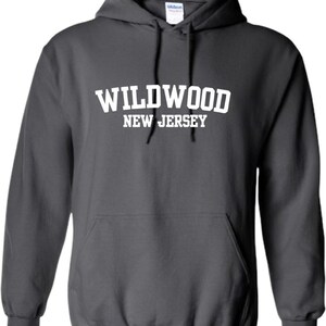 May include: A dark gray hooded sweatshirt with the text "WILDWOOD NEW JERSEY" printed in white on the front.