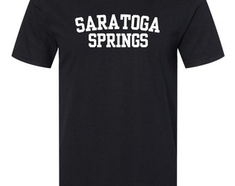 Puede incluir: Camiseta negra con texto blanco que dice "SARATOGA SPRINGS" en una fuente de estilo universitario.
