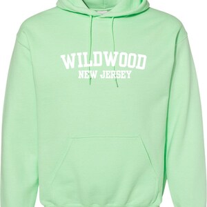 May include: A light green hooded sweatshirt with the text "WILDWOOD NEW JERSEY" in white.