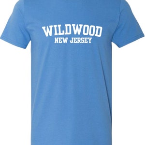 K&ouml;nnte beinhalten: Ein hellblaues T-Shirt mit wei&szlig;em Text, der "WILDWOOD NEW JERSEY" lautet.