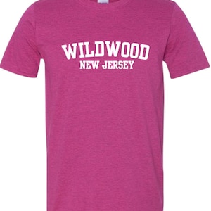 K&ouml;nnte beinhalten: Ein pinkfarbenes T-Shirt aus Heather-Material mit wei&szlig;em Text, der "WILDWOOD NEW JERSEY" lautet.