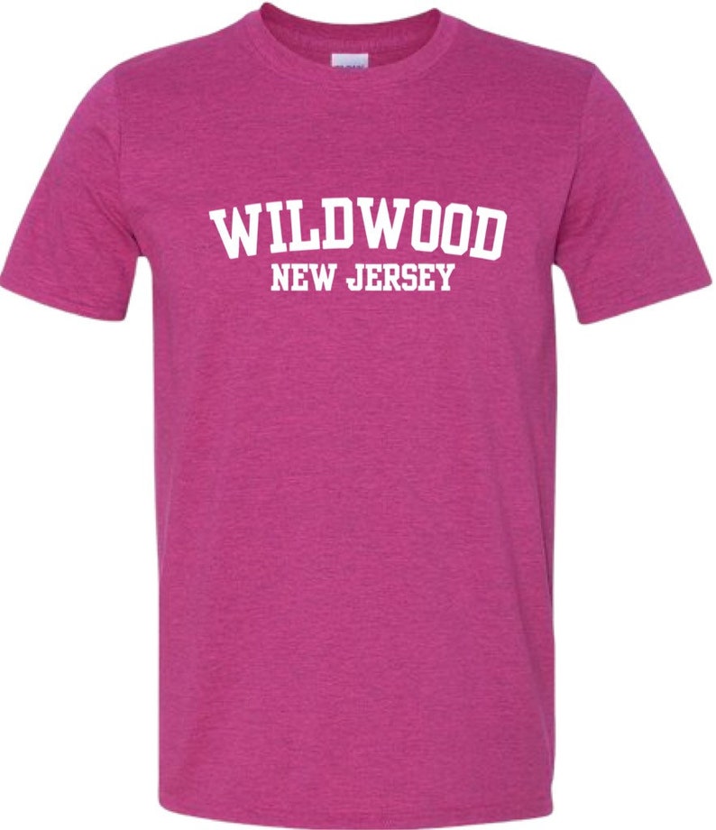 K&ouml;nnte beinhalten: Ein pinkfarbenes T-Shirt aus Heather-Material mit wei&szlig;em Text, der "WILDWOOD NEW JERSEY" lautet.