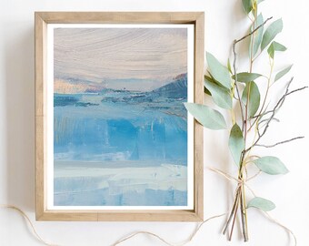 May include: Abstract painting in shades of blue and white, framed in a light wood frame. The painting depicts a landscape with a horizon line and a sky with clouds.