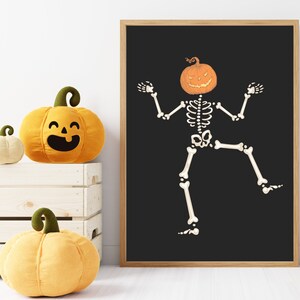 Dancing skeleton pumpkin head wall art with wood frame on black background; white skeleton, orange jack-o-lantern.