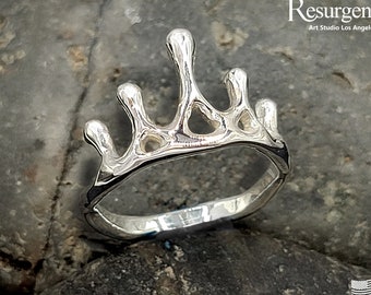 May include: A silver crown ring with a unique, organic design. The ring is made in the USA.