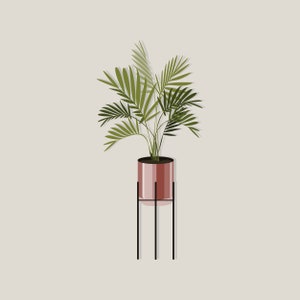 May include: A potted plant with green leaves in a pink planter on a black metal stand.