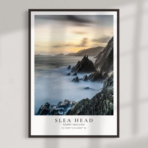 Puede incluir: Una impresión enmarcada que presenta un paisaje costero al atardecer. La imagen muestra acantilados oscuros y escarpados que se encuentran con el océano, con una atmósfera brumosa. El texto "SLEA HEAD, KERRY IRELAND" está en la parte inferior.