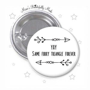 以下が含まれることがあります： 「Yay Same Furry Triangle Forever」と書かれた黒い文字と矢印のある白いボタン。