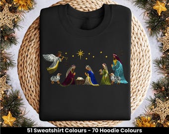 May include: Black sweatshirt with a colorful embroidered image of the nativity scene. The scene includes a star, a manger, an angel, Mary, Joseph, and three wise men.