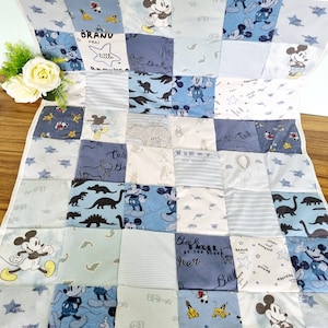 May include: A blue and white patchwork baby quilt with a Mickey Mouse theme. The quilt is made of various fabrics, including cotton and flannel. It features a variety of Mickey Mouse designs, including Mickey Mouse heads, Mickey Mouse ears, and Mickey Mouse silhouettes. The quilt also features the words "BRAND NEW LITTLE BROTHER", "MUMMY", "TELL", "DOKER", and "BALKER BY THE PIER".
