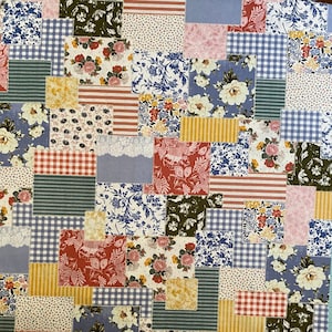 May include: A patchwork fabric with a variety of floral, striped, and gingham patterns in shades of blue, pink, yellow, and red. The design features a mix of different fabric squares sewn together, creating a textured and colorful textile.