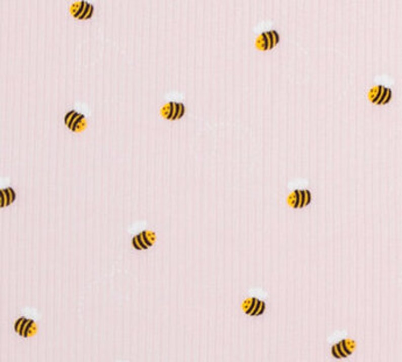 Puede incluir: Tela de color rosa con textura de canal&eacute; y un patr&oacute;n repetitivo de peque&ntilde;as abejas amarillas.