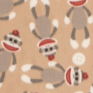 May include: Tan fabric with a repeating pattern of gray sock monkeys wearing red hats. The monkeys have white feet and are in various positions.