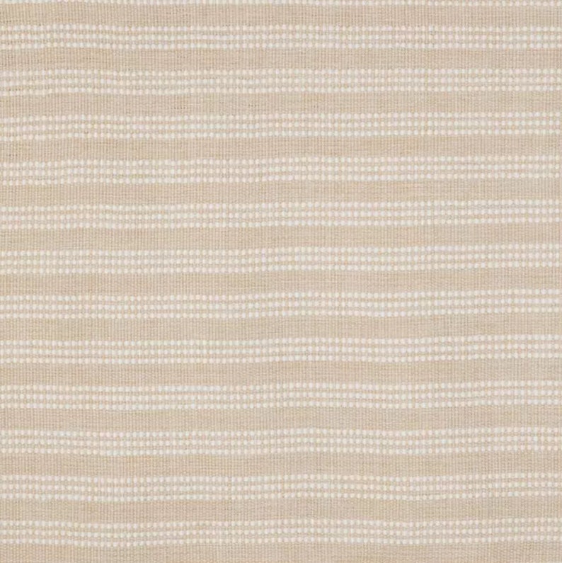 Op de afbeelding: Een close-up van een beige stof met witte strepen. De stof heeft een subtiele textuur en een licht ruw gevoel.