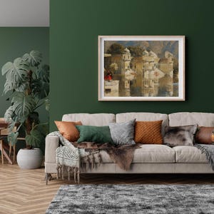 K&ouml;nnte beinhalten: Ein hellgraues Sofa mit einer Wolldecke und Kissen in einem Wohnzimmer mit einer gr&uuml;nen Wand und einem gerahmten Gem&auml;lde einer Stadtlandschaft &uuml;ber dem Sofa.