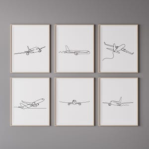 May include: Set of six minimalist black and white line art prints featuring different airplane designs. Each print is framed in a simple wooden frame.
