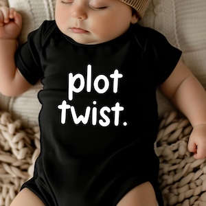 May include: A black baby onesie with white text that reads "plot twist."