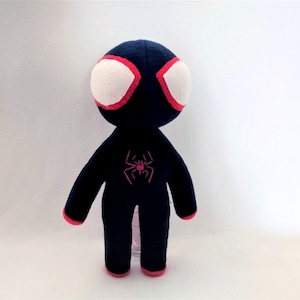 May include: Black and red plush toy of Spider-Man with a white face and a red spider symbol on the chest.