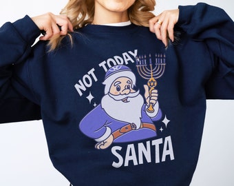 Könnte beinhalten: Ein marineblauer Pullover mit einer Cartoon-Illustration von Weihnachtsmann, der eine Menora hält. Der Text "NOT TODAY SANTA" ist auf dem Pullover aufgedruckt.