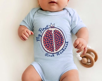 May include: A light blue baby onesie with a graphic of a pomegranate and the text "My First Rosh Hashanah".