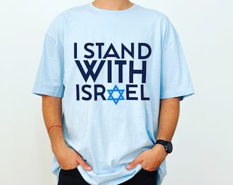May include: A light blue t-shirt with the text "I Stand With Israel" and a blue Star of David.