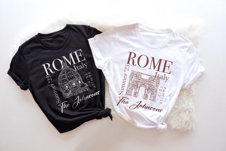 May include: Two black and white t-shirts with a graphic design of Roman landmarks. The text on the shirts reads "ROME Summer '23 Italy Family Trip The Johnsons".