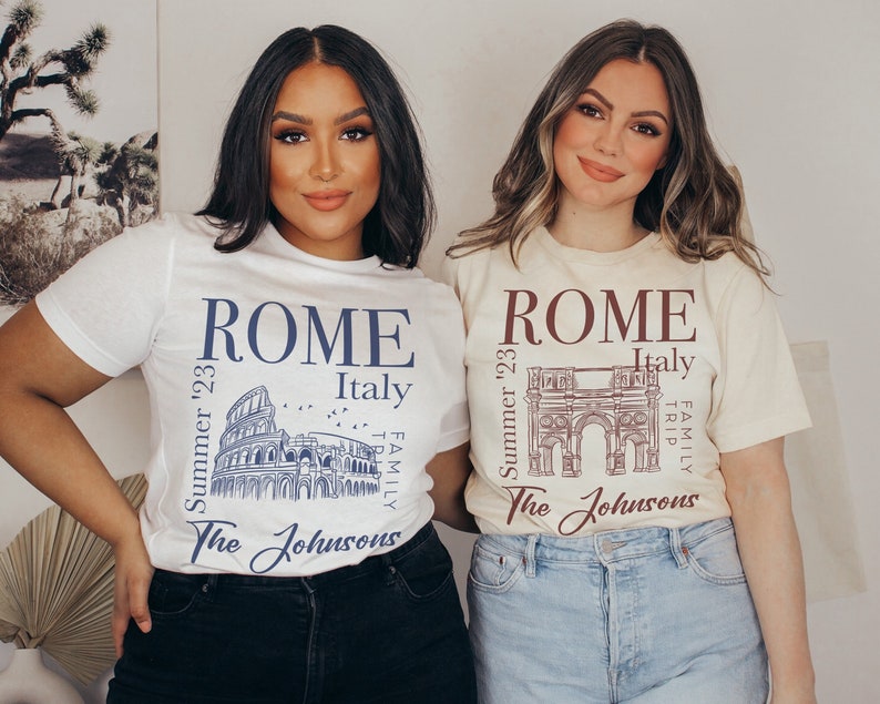 May include: Two people wearing white and beige t-shirts with a graphic design of the Colosseum and the Arch of Constantine in Rome, Italy. The shirts say "ROME" and "Summer '23" with the text "The Johnsons" at the bottom.