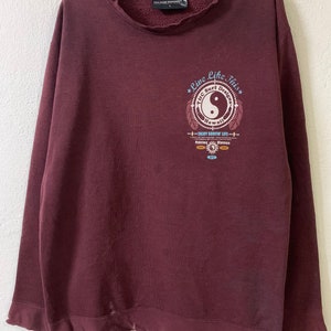 Puede incluir: Sudadera color burdeos con un estampado gr&aacute;fico de un s&iacute;mbolo yin yang con el texto "Live Like This" y "TGC Surf Designs Hawaii" alrededor.