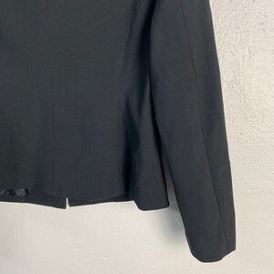 May include: A black blazer with long sleeves and a cropped hem.