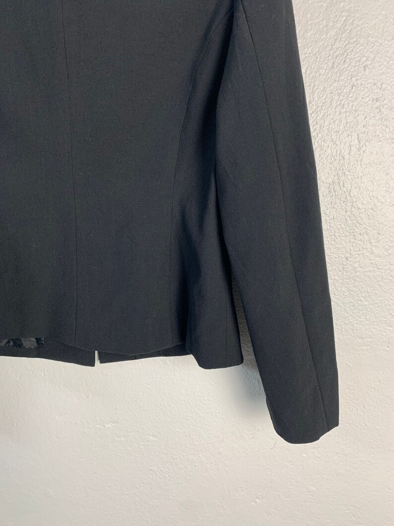 May include: A black blazer with long sleeves and a cropped hem.