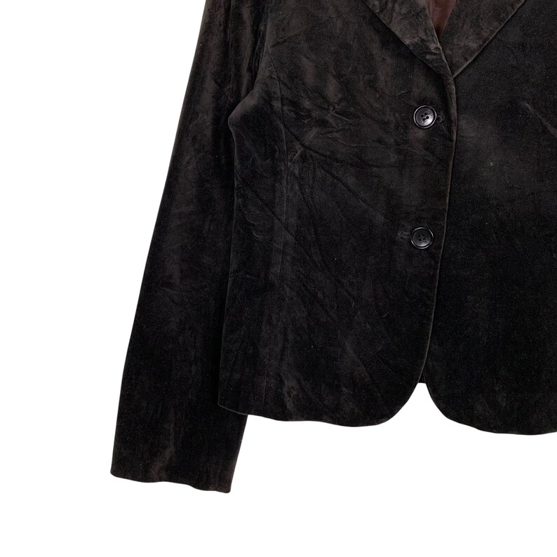 Peut inclure: Un blazer en velours marron fonc&eacute; avec deux boutons noirs. Le blazer a un design classique et ajust&eacute; avec un revers crant&eacute; et des manches longues. Le tissu semble doux et a un &eacute;clat subtil.