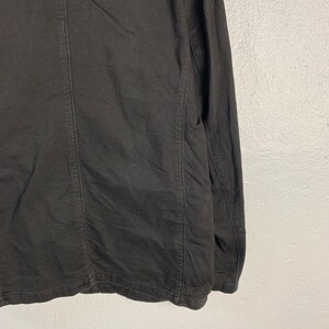 Puede incluir: Chaqueta negra de manga larga con costuras visibles y tejido texturizado. La chaqueta tiene un dise&ntilde;o cl&aacute;sico con un corte entallado. La prenda est&aacute; hecha de un material oscuro y de color s&oacute;lido.
