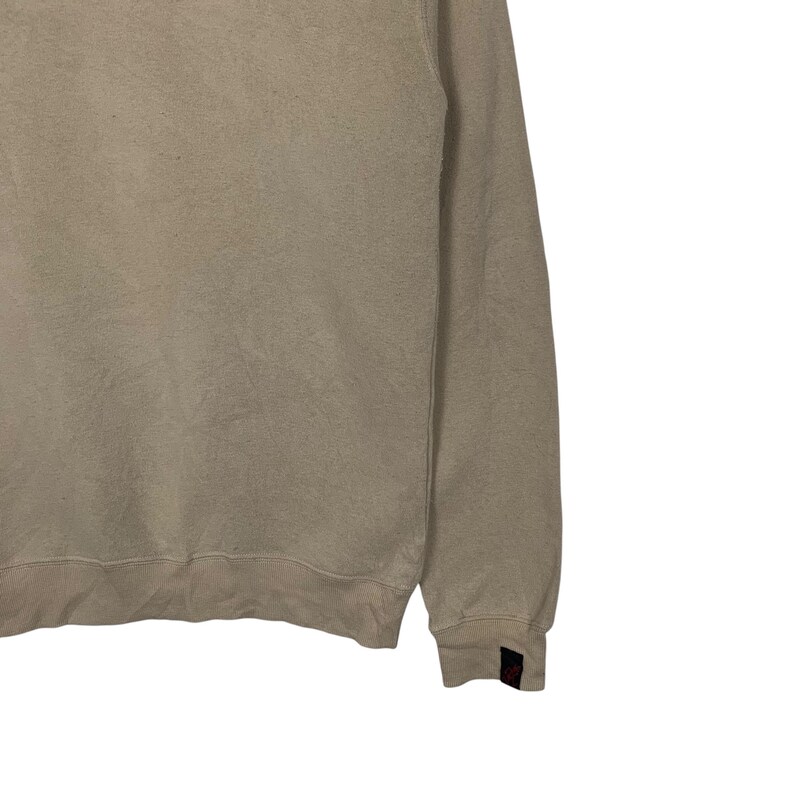 May include: A light beige sweatshirt with long sleeves and a crew neck. The sweatshirt is made of a soft, comfortable fabric.