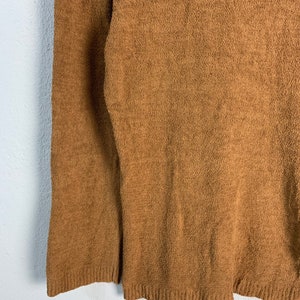 Puede incluir: Un su&eacute;ter marr&oacute;n peludo con mangas largas.