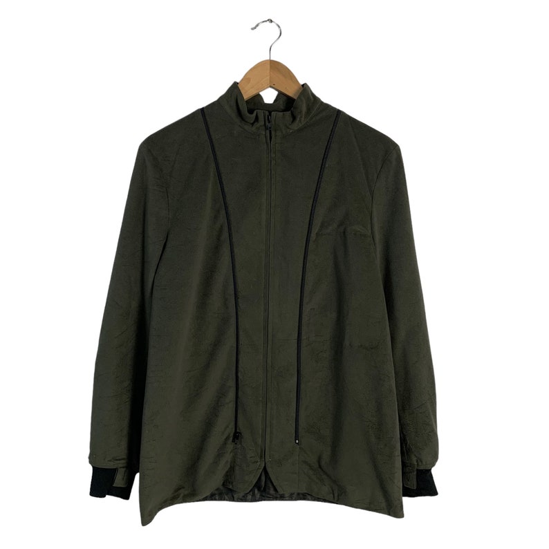 May include: A dark green zippered jacket with black trim. The jacket has a stand-up collar and long sleeves.