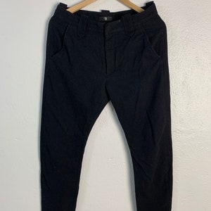 Peut inclure: Pantalon noir avec braguette boutonnée et deux poches avant. Le pantalon a une petite étiquette avec la lettre "U" sur la ceinture.