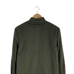 May include: A dark green long-sleeved turtleneck sweater with a black trim around the neckline.