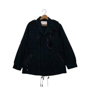 May include: A black jacket with multiple pockets, zippers, and decorative embellishments. The jacket features a collared neckline, long sleeves, and a drawstring at the waist. Small silver beads and tassels add detail to the front of the jacket.
