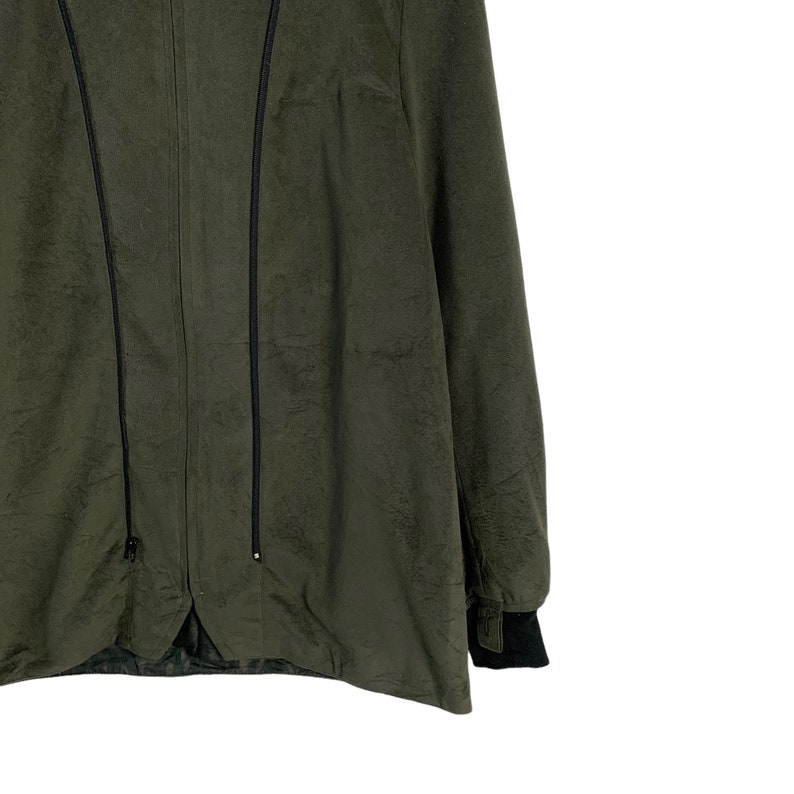 May include: A dark green jacket with a zipper closure and black trim. The jacket has a long sleeve and a relaxed fit.