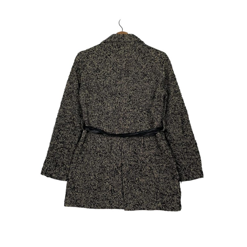 Puede incluir: Un abrigo largo texturizado en tonos negro, gris y beige, con un cintur&oacute;n negro en la cintura. El abrigo tiene un cuello cl&aacute;sico y mangas largas, perfecto para el clima fresco. El abrigo est&aacute; colgado de una percha de madera.