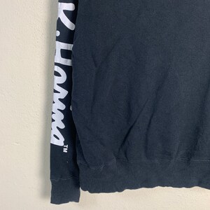 May include: Black long-sleeve sweatshirt with white lettering on the left sleeve that says "K-Swiss" with a trademark symbol.