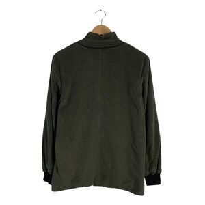 May include: A dark green long-sleeved shirt with a mock neck and black trim around the neck and cuffs.