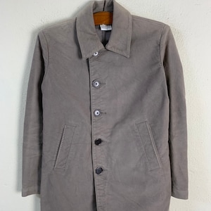 May include: A grey long-sleeved jacket with a button-up front and two pockets. The jacket has a collar and is hanging on a wooden hanger.