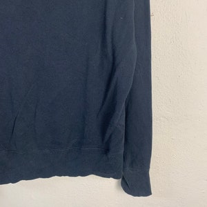 May include: A dark blue long-sleeved sweater with a ribbed knit texture.