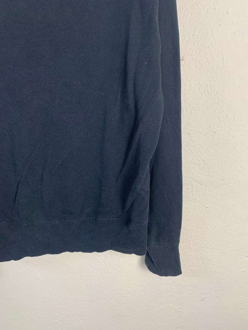 May include: A dark blue long-sleeved sweater with a ribbed knit texture.