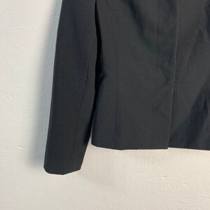 May include: A black blazer with long sleeves and a button closure.